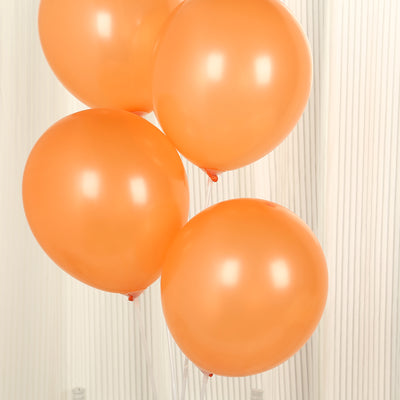 Orange balloons in a cluster against a light background.