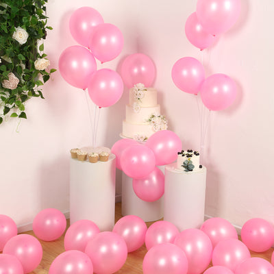Pink balloons, cake, and cupcakes arranged for a festive celebration.