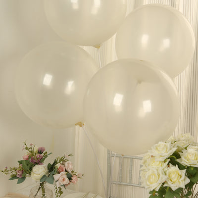 Elegant cream balloons with ribbons beside a floral arrangement.
