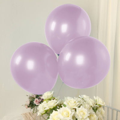 Three lavender balloons floating above a bouquet of white roses.