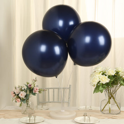 Navy blue balloons on a table with flowers and plates.