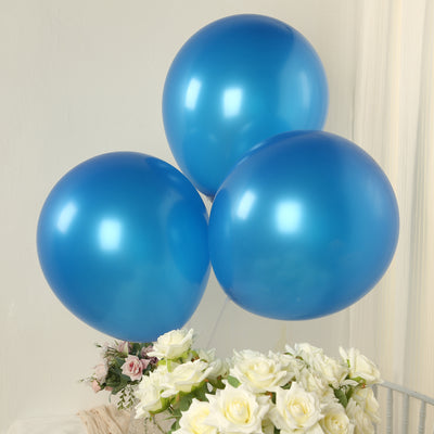 Three glossy blue balloons floating above white roses.
