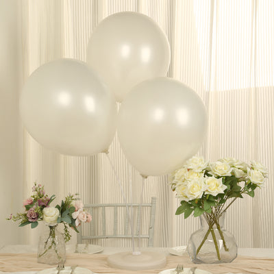 White balloons with flowers on a table in a bright, elegant setting.