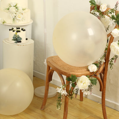 Transparent balloon on a wooden chair decorated with flowers in a styled setting.