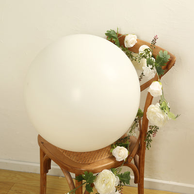White decorative ball on a wooden chair with floral accents.