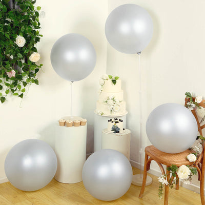 Silver balloons arranged decoratively with cake and floral accents in a stylish setting.