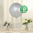 Silver biodegradable balloon on a table with floral arrangements.