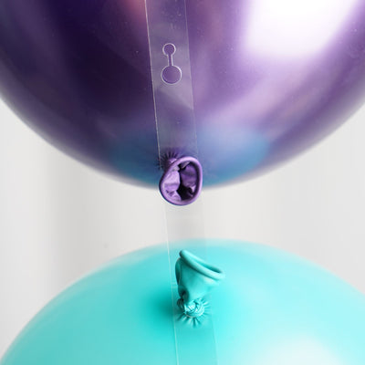 Two balloons, one purple and one teal, connected by a clear strip.