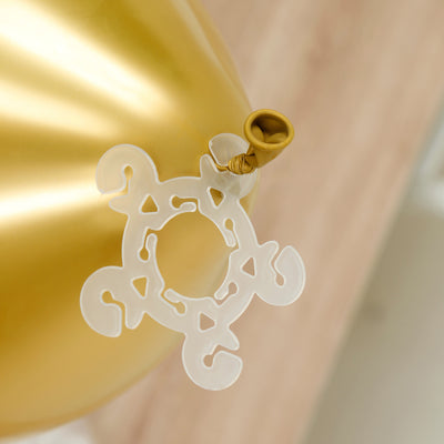 Gold balloon with a clear balloon tie on a light wooden surface.