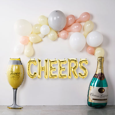 Gold "CHEERS" balloons with champagne glass and bottle decoration.