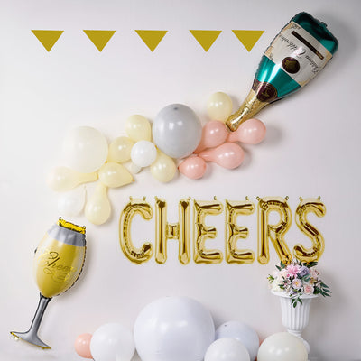 Festive "Cheers" decorations with balloons and champagne bottle backdrop.