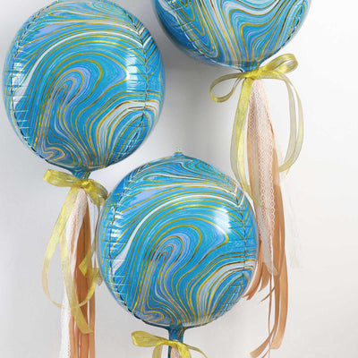 Blue marbled balloons with gold and cream ribbons hanging decoratively.