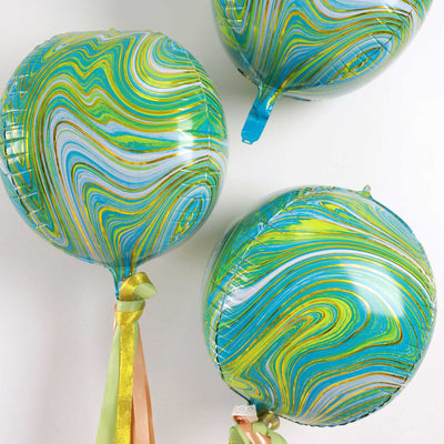 Colorful marbled balloons in shades of blue and green with ribbons.