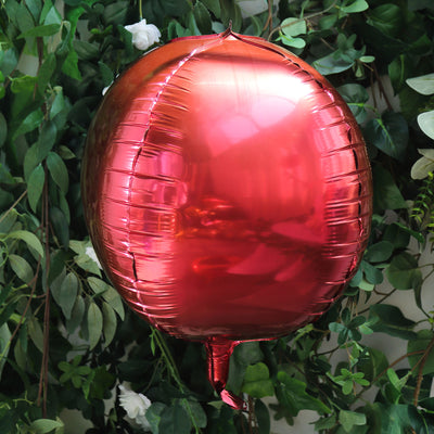 Red foil balloon against green foliage backdrop.