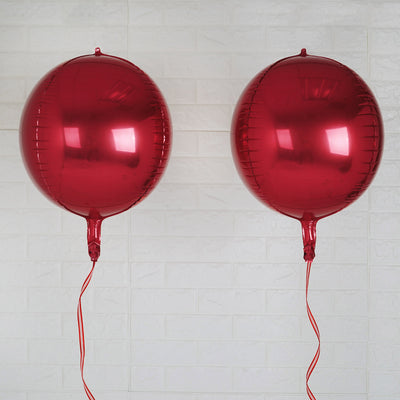 Two shiny red balloons with ribbons on a white background