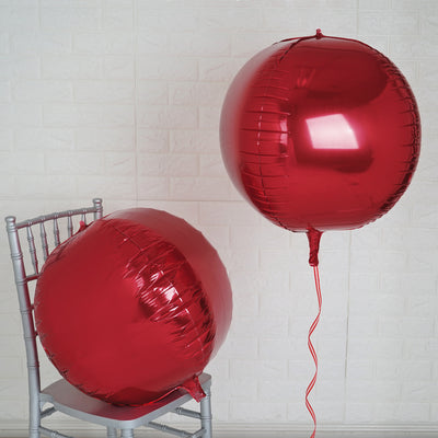 Red foil balloons on a silver chair against a white background.