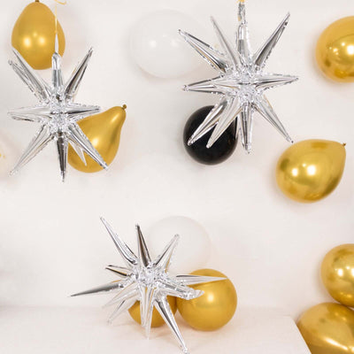 Silver star-shaped party decorations with gold and black balloons.