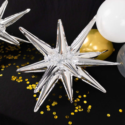 Silver star-shaped balloon surrounded by confetti and balloons.