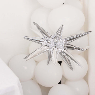 Silver star decoration among white balloons for festive occasions.