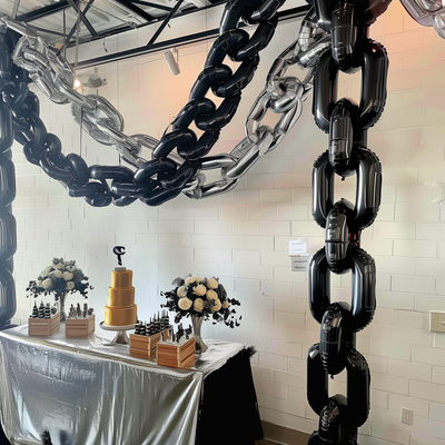 Decorative balloon chains and a cake display at an event.