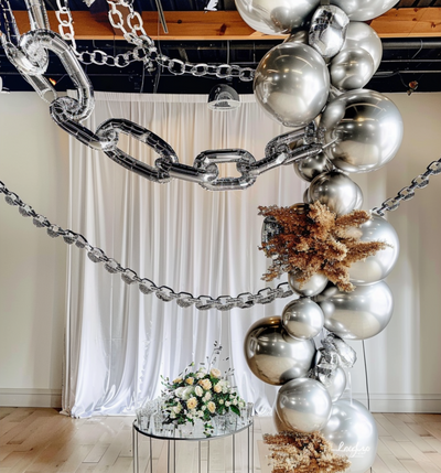Decorative silver balloons and chains with floral arrangement in a stylish event space.