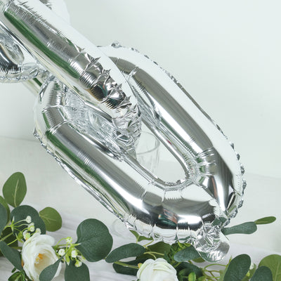 Silver balloon chain decoration with greenery accents.