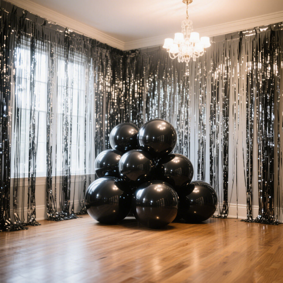 Black balloons arranged in a festive display against a decorated backdrop.