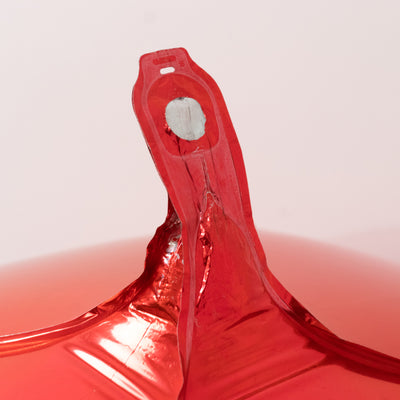 Red balloon with a clear tag and knot detail on a plain background.