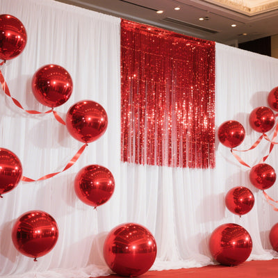 Red balloons and shiny backdrop for festive event decor.
