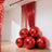 Shiny red balloons clustered in a stylish indoor setting.