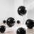 Black glossy balloons in a modern setting with a shiny backdrop.