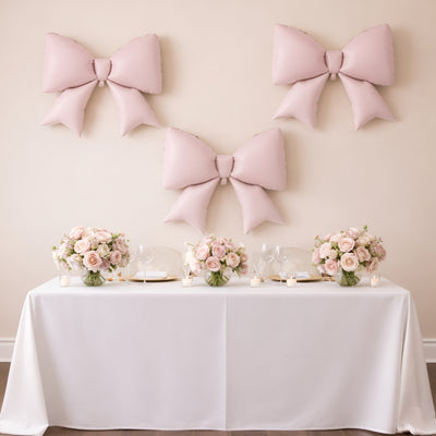 Elegant pink bows and floral centerpieces on a beautifully set table.