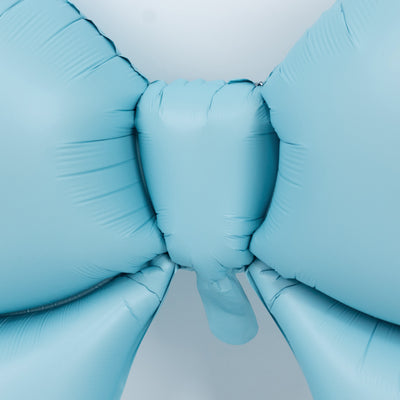 Blue balloon bow decoration on a plain background