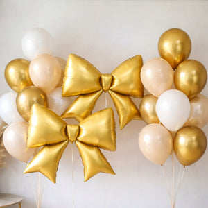 Gold balloon bows with assorted balloons in a festive arrangement.