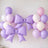 Purple and pink balloons with large bows for festive decor.