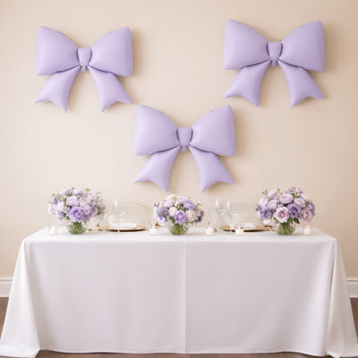 Lavender bows and floral centerpiece on a table for a wedding or event decor.