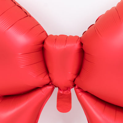 Red inflatable bow decoration, ideal for festive events or gifts.