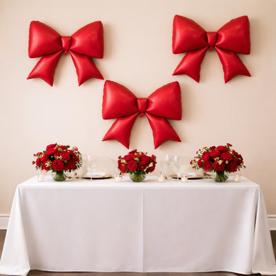 Red balloons and floral arrangements on a decorated table for a festive event.