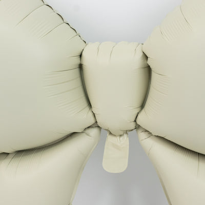 Beige balloon bow against a plain backdrop