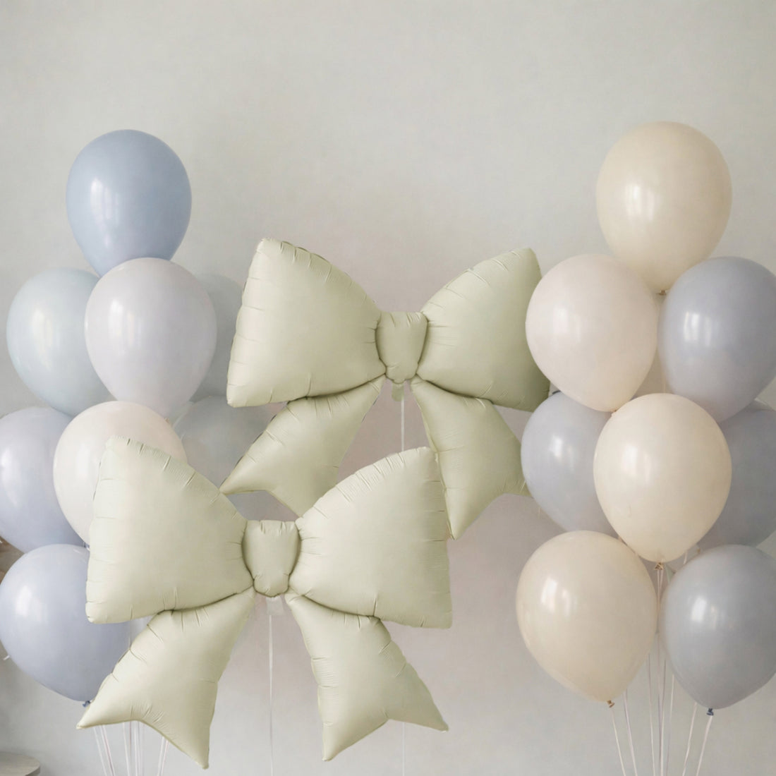 Two large decorative bows surrounded by pastel balloons.
