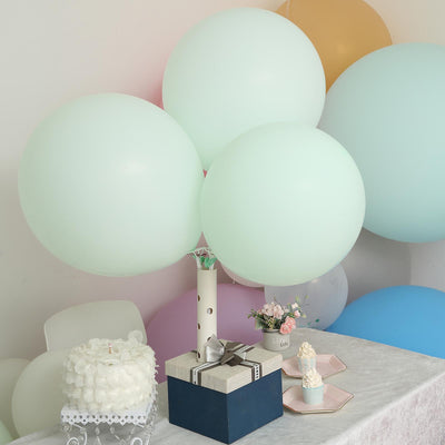 Decorative pastel balloons at a party table with cake and gifts.