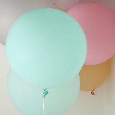 Colorful balloons in pastel shades floating against a white background