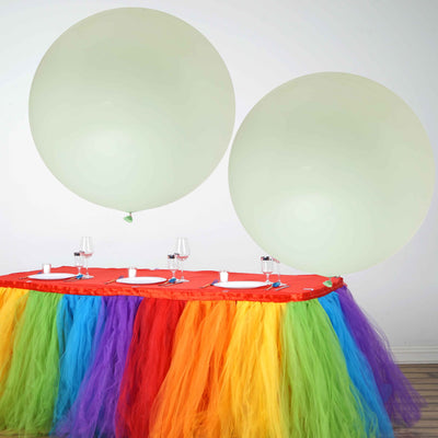 Colorful party table with large balloons and vibrant tulle decorations.
