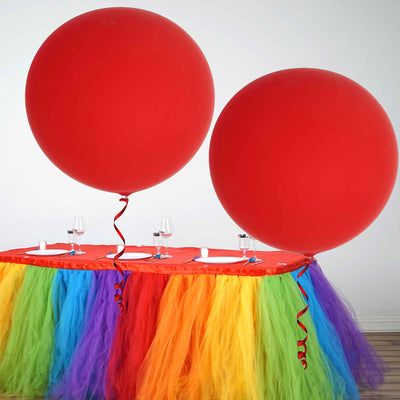 Red balloons on a colorful table with tulle decorations for a festive event.