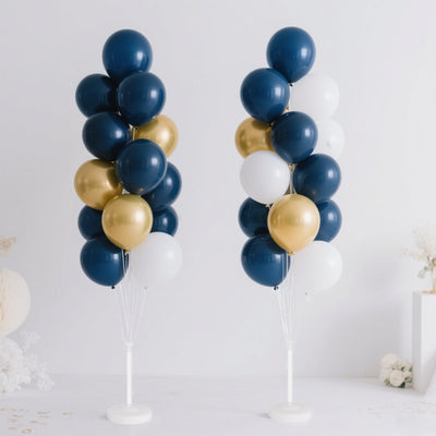 Navy, gold, and white balloon bouquet towers on a plain backdrop