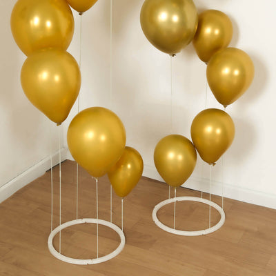 Gold balloons arranged in two clusters on a wooden floor.
