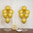 Gold balloons and a dessert stand with cupcakes on a wooden table.
