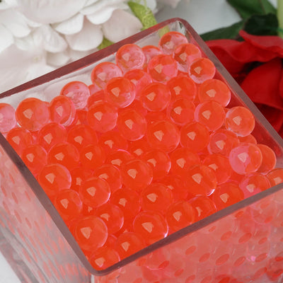 Red decorative water beads in a glass container.