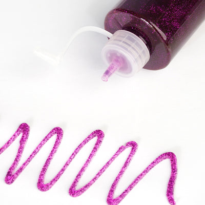 Purple glitter glue bottle with a swirl of glittery purple glue on white background.