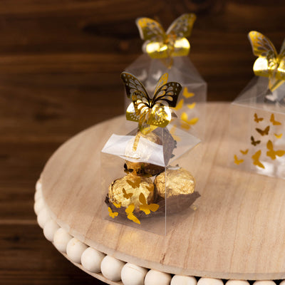 Clear gift boxes with golden butterfly decorations and chocolate truffles inside.